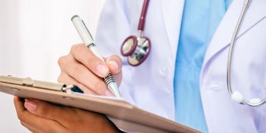 Doctor writing on clipboard