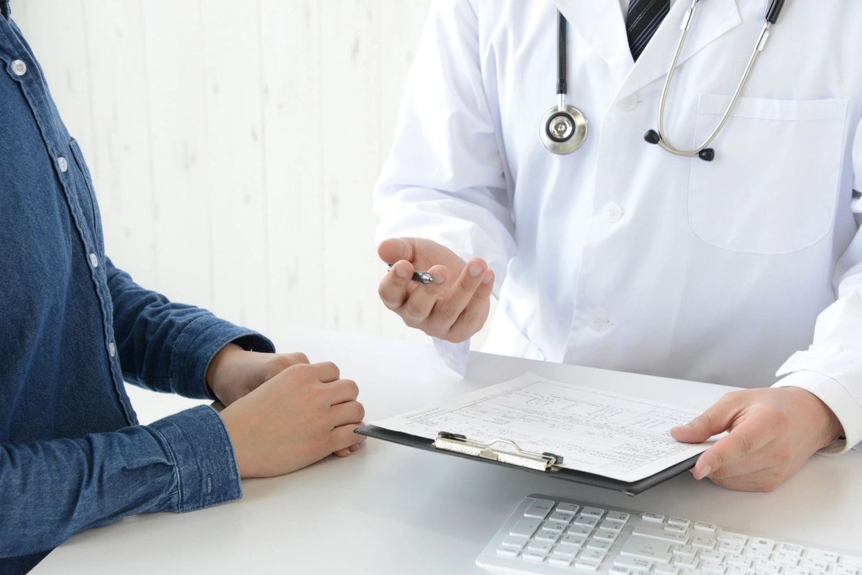 Doctor reviewing patient health records during physical exam